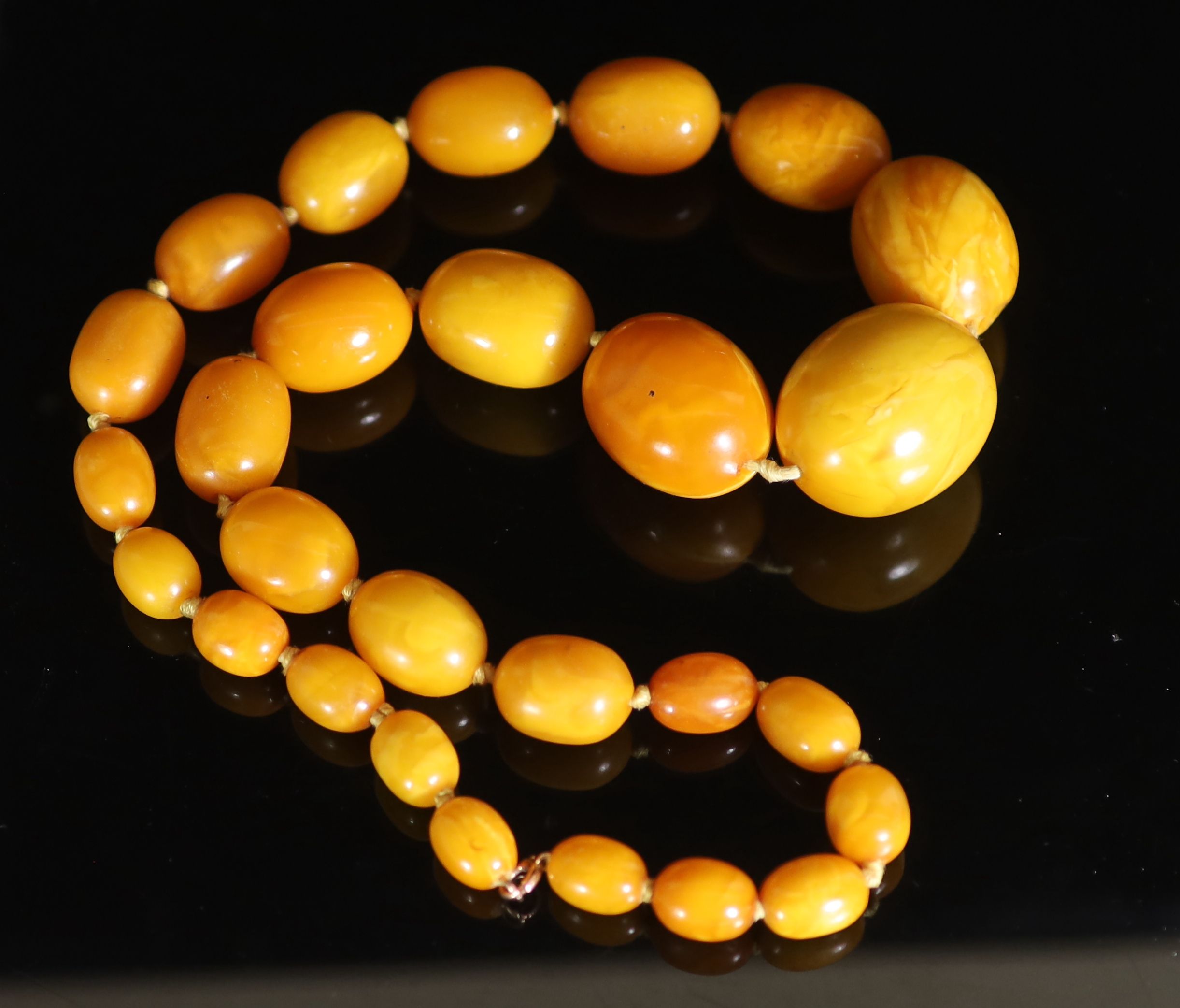 A single strand graduated oval amber bead necklace